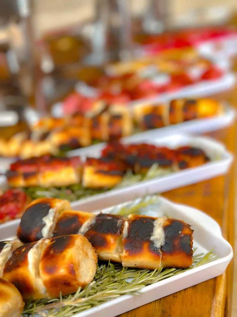 Pão de alho artesanal e petiscos de churrasco sobre ramo de alecrim fresco